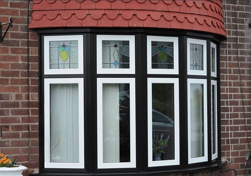 Black Liniar flush sash bay window with stained-glass upper lights