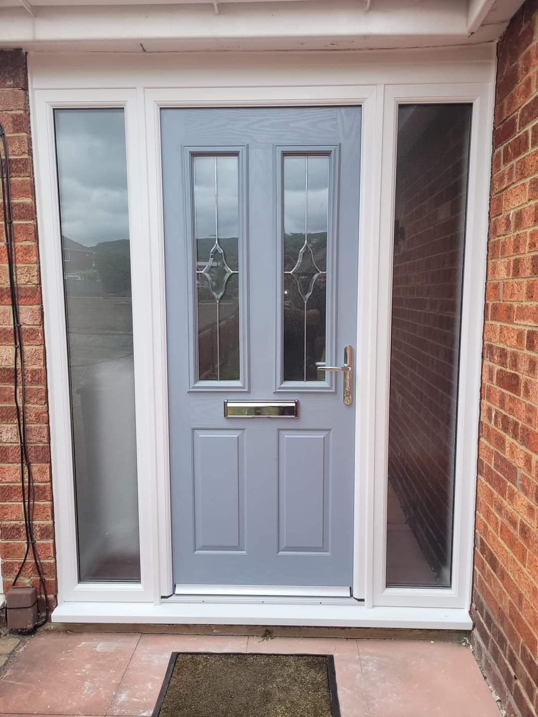 Light grey composite front door with decorative glass and twin sidelights