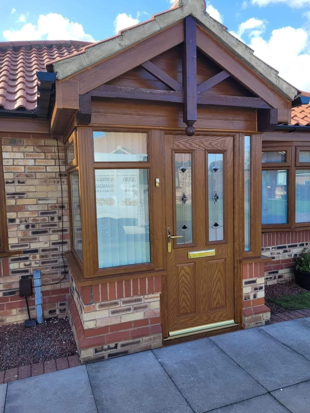 Rosewood porch installation with decorative glazed entrance door