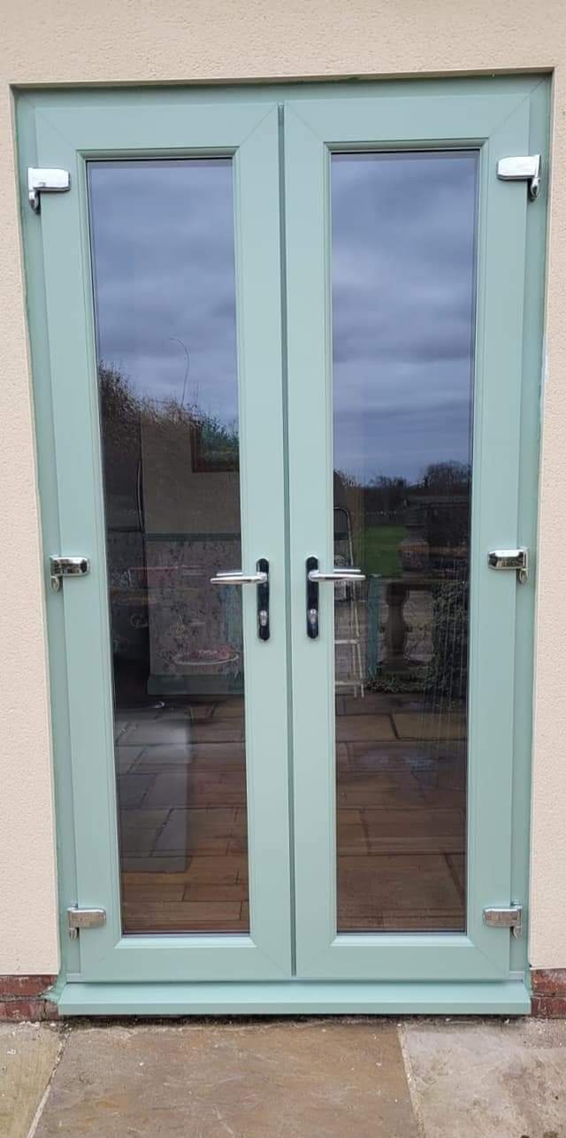 Chartwell green uPVC French doors opening onto a patio