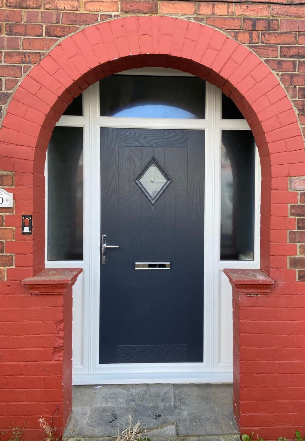 Anthracite grey composite door with arched brick surround