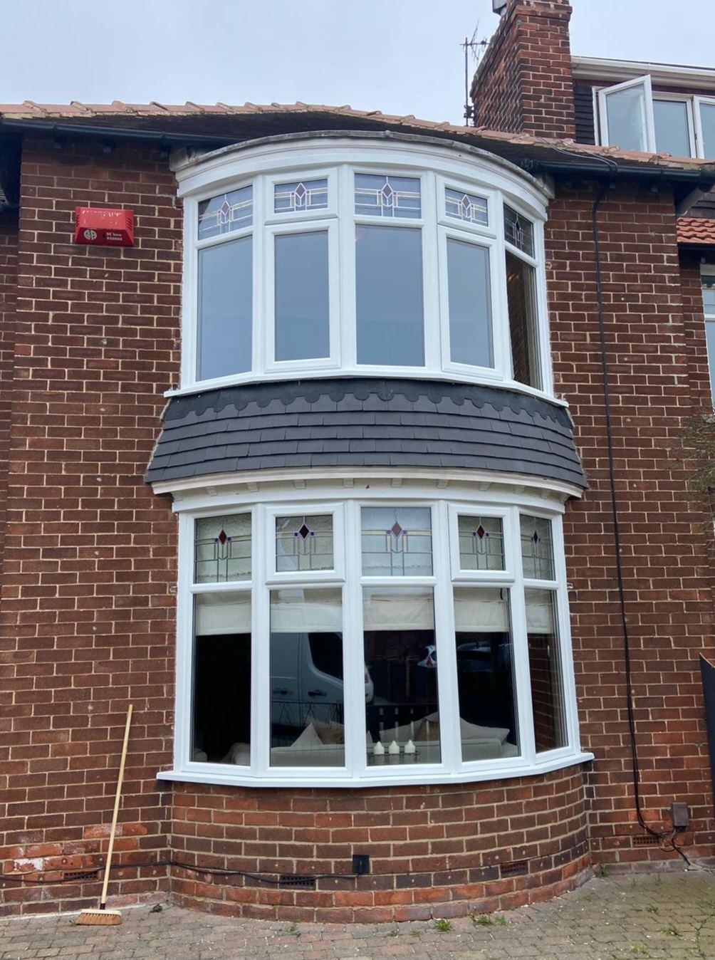 Two-tier white uPVC bay window with decorative leaded glass