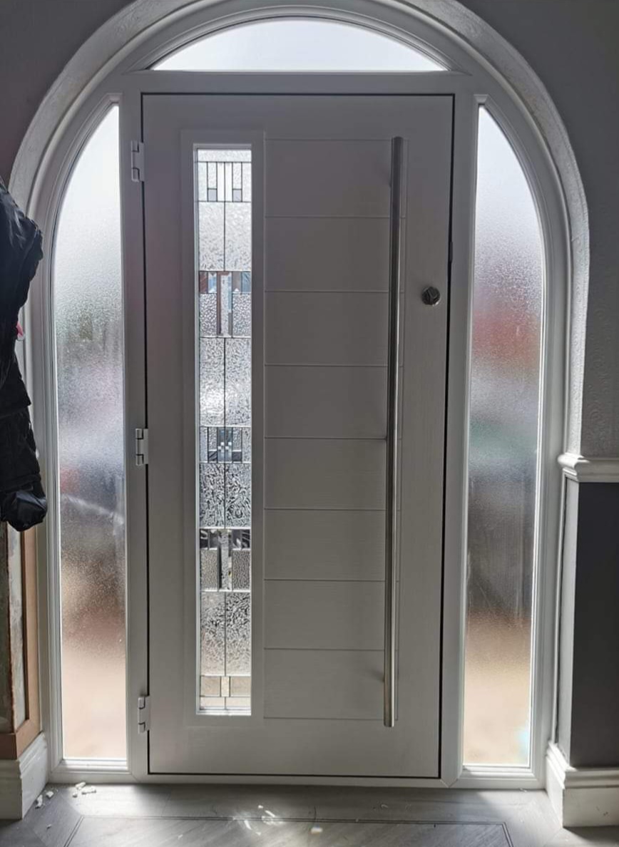 White composite door set within an arched frame with obscure glazing — interior view
